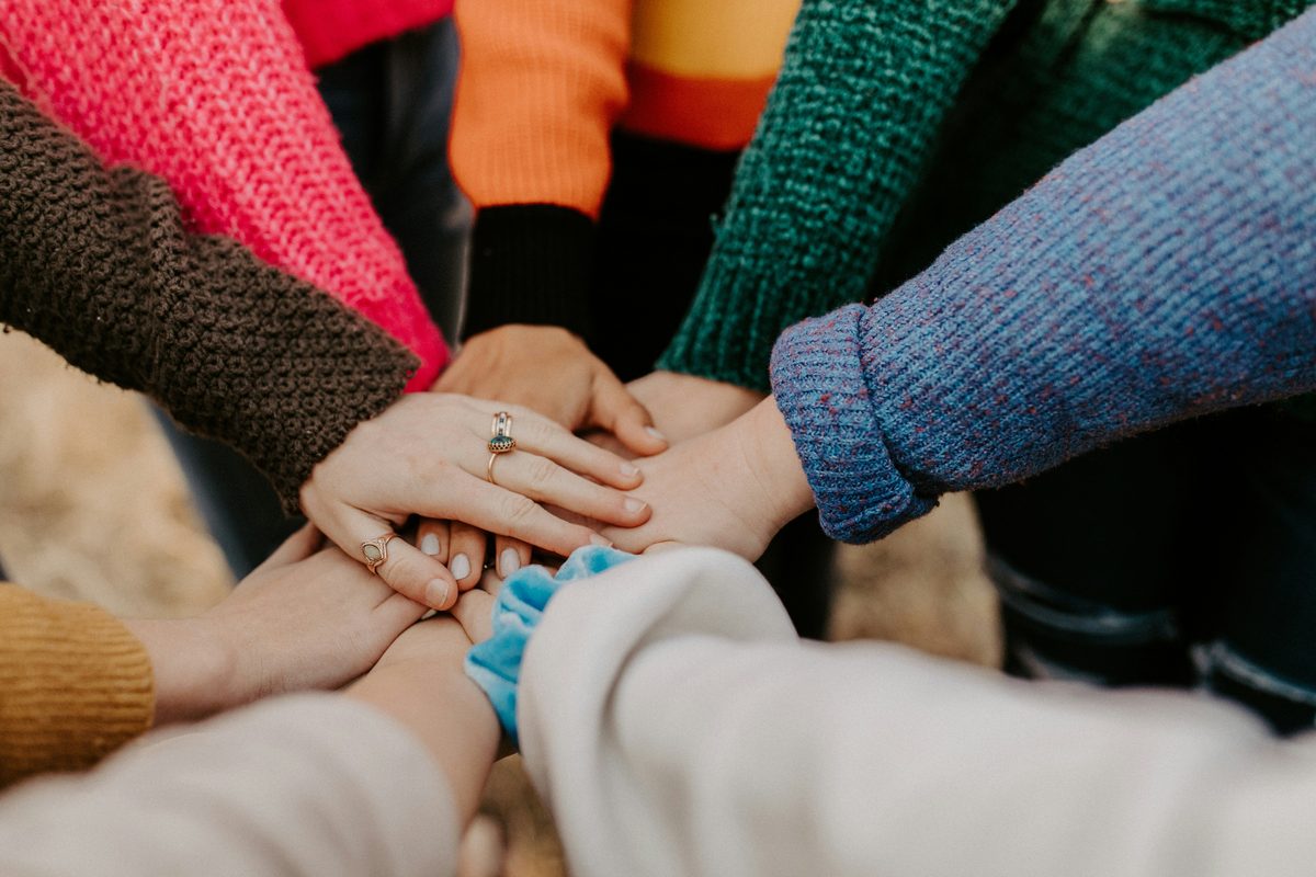 A group of people joining hands together in support